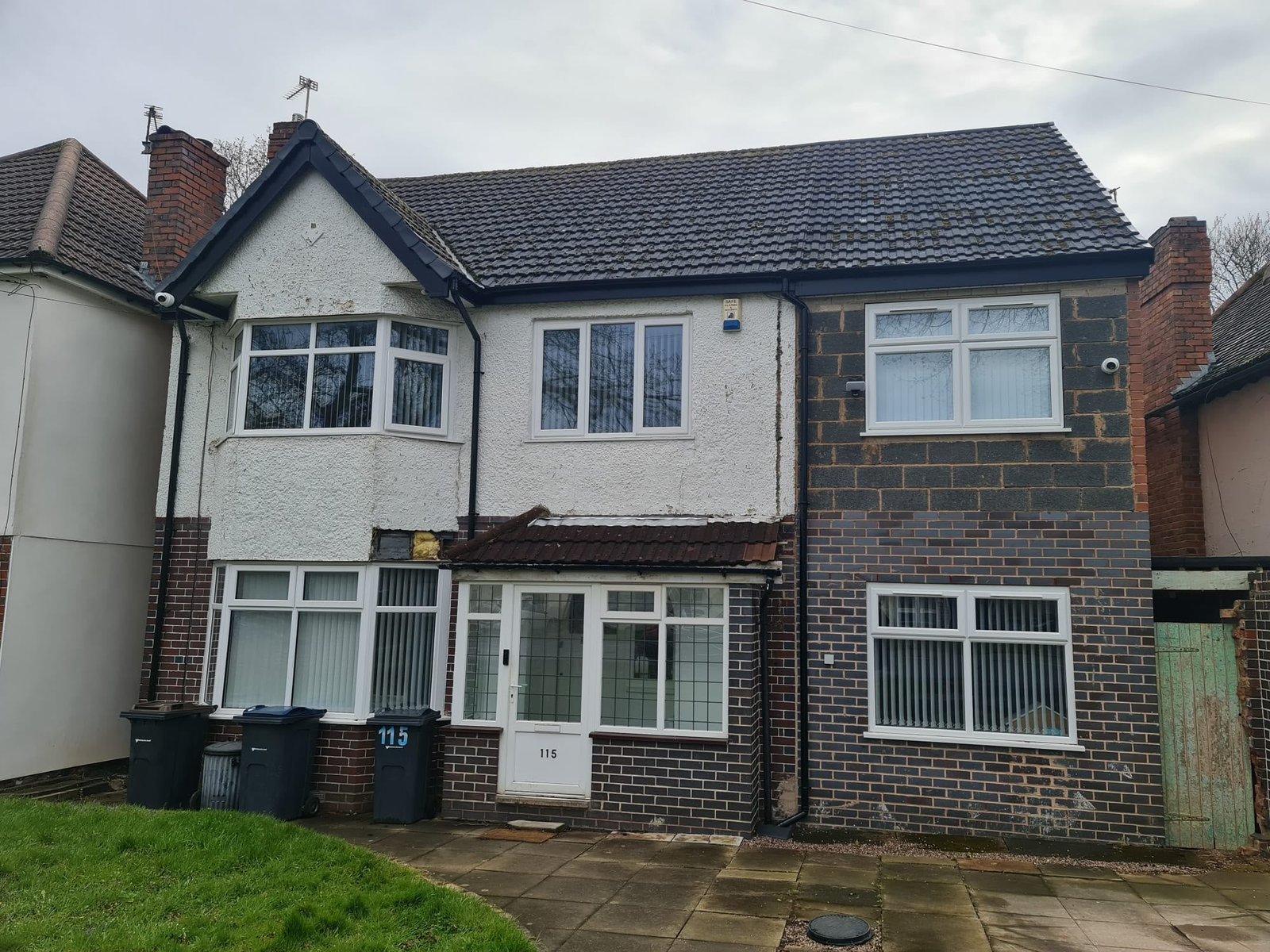 Cracked roughcast render and mismatched brickwork on the front of a house in Kings Heath, Birmingham before external wall insulation
